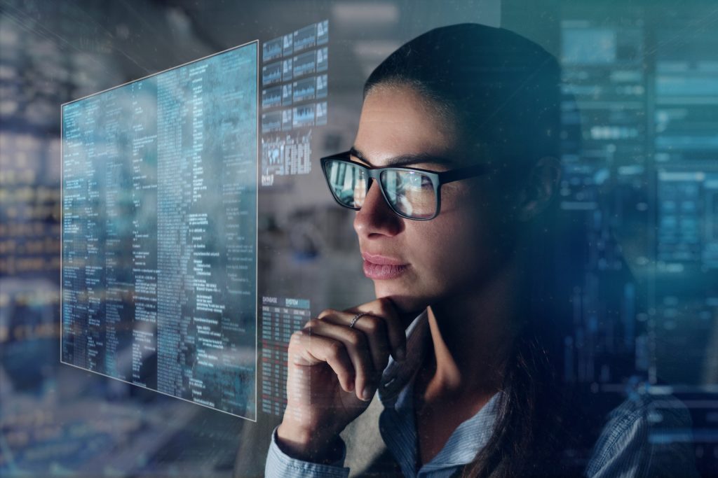 Which Tech Roles Are Most In-Demand Right Now & How Women Can Break Into Them Women working with a computer with holograms. Concept: Future, technology, work