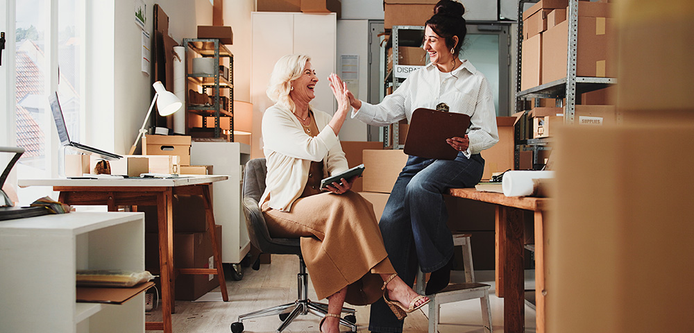 Why Most Small Businesses Are Invisible Online — And How to Fix It Ecommerce, people and high five with tablet, success or clipboard for sales target in small business. Manager, happy women and celebration in office with tech, checklist or achievement for logistics